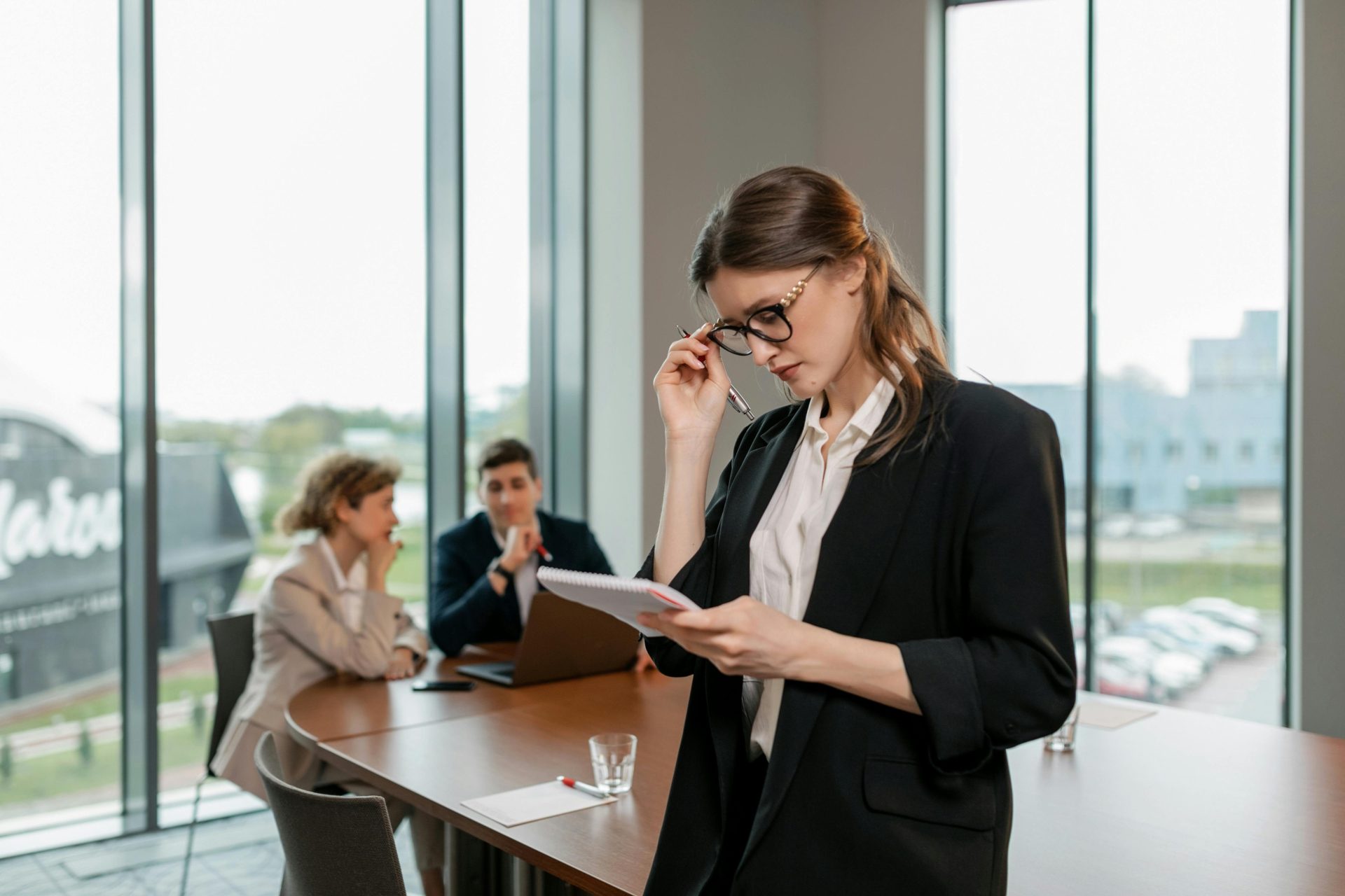 Selbstbewusste Frau, die in einem modernen Büro die Notizen einer Geschäftsbesprechung durchgeht.